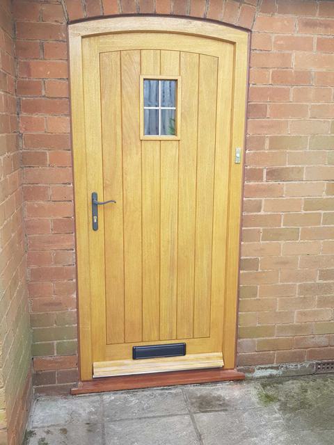 Arched timber cottage door with window